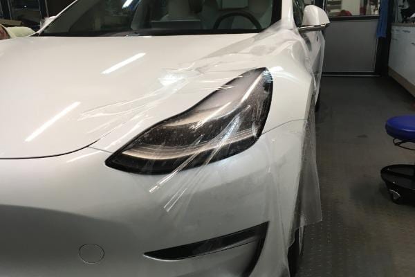 Transparente Lackschutzfolie bei der Montage an einem Fahrzeug