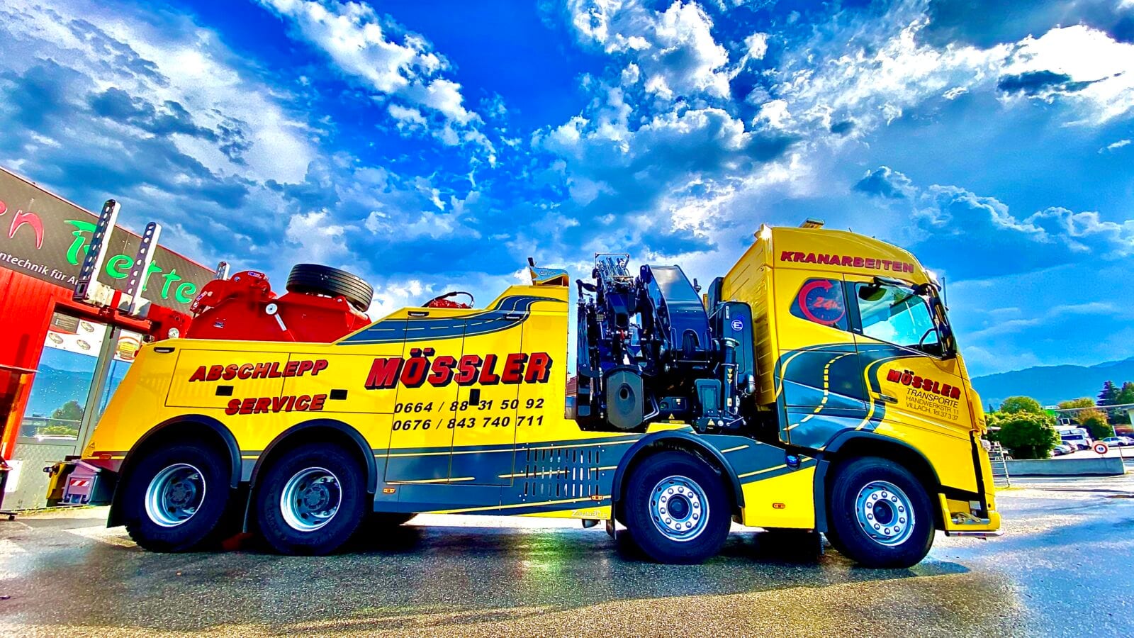 Beschrifteter gelber Abschlepp-Lkw